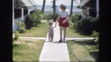 Florida (1945): Woman Wearing Red Skirt Picks Up Toddler Wearing Pink Overalls