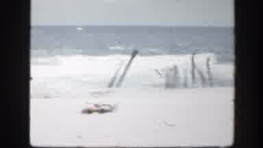 FLORIDA-1945: Black And White Video Of A Beach With The Waves Crashing Against Wooden Posts
