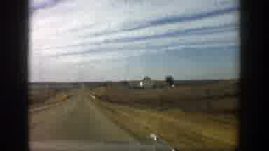 Aspen Colorado (1961): A Vehicle Drives Down A Rural Highway By Farm Houses And