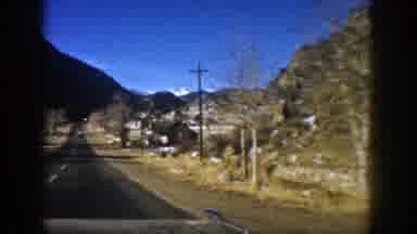 Aspen Colorado (1961): Approaching View Of Brown House On Side Of Road On A Sunny