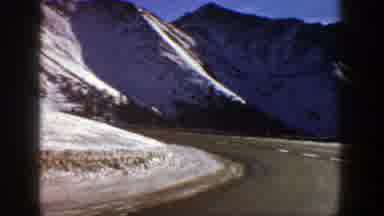 Aspen Colorado (1961): Twisting Road With Snow Covered Mountains And Trees To The
