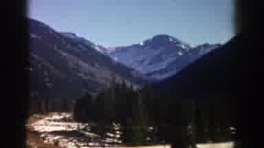 Aspen Colorado (1961): Driving On The Road Surrounded By Trees And Mountains And