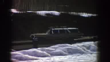Aspen Colorado (1961): Beige Green Car Driving Down A Clear Road Outside The Snow