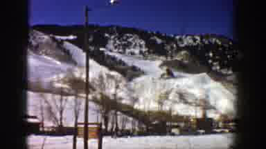 Aspen Colorado (1961): View Of Snow Covered Mountains And Person Sitting In Ski