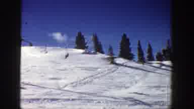 Aspen Colorado (1961): People Ride Up A Chairlift To Go Skiing On A Snowy Mountain
