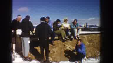 Aspen Colorado (1961): Group Of People Share Sitting On A Large Snow Covered Rock