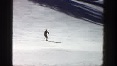 Aspen Colorado (1961): Person Wearing Grey Jacket Makes Small Jump On Skis On A