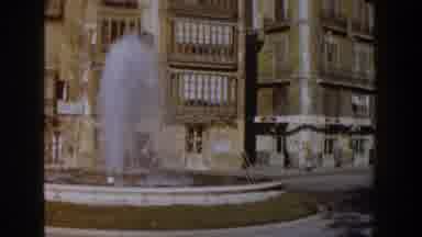 Italy (1960): View Of Water Fountain And Tan Building On A Sunny Day
