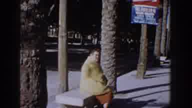 Italy (1960): A Woman In A Yellow Jacket Sitting In A Square Surrounded By