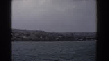 Italy (1960): View Of City Buildings And Grey Boat In Sea In A Cloudy Day