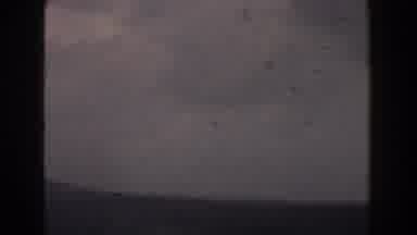 Italy (1960): View Of Birds Flying Above Ocean Water On A Cloudy Day