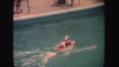 California (1962): A White Dog Walking On A Small Boat In The Water Of A Swimming