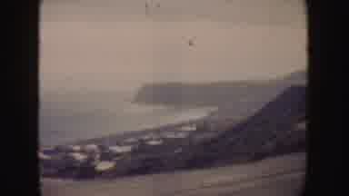 California (1962): Slowly Driving Scenic Route Across Coastline Road Near Town
