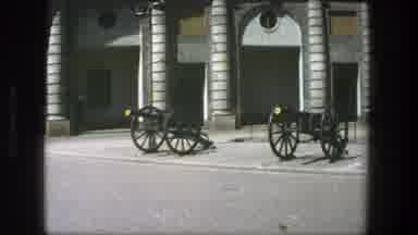 Stockholm Sweden (1975): Pair Of Black Cannons Sit In Front Of Tan Building On A