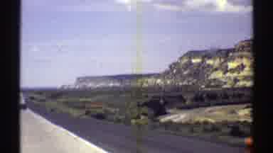 Arizona (1969): Approaching View Of Brown Mesa Blue Sky And White Puffy Clouds