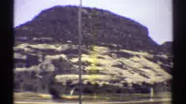 Arizona (1969): Driving On The Road Cars And Hills And Mountains With Vegetation