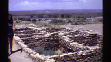 Arizona (1969): Woman Wearing Blue Dress Walks Stone Pits On A Bright Sunny Day