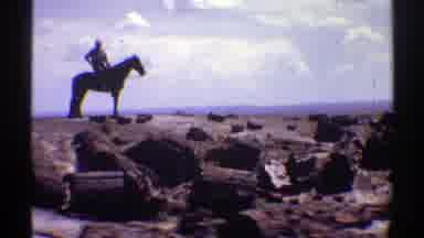 Arizona (1969): A Man On A Black Horse With Several People In A Very Large Desert