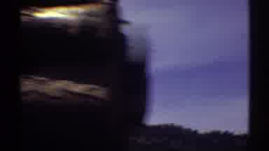 Arizona (1969): Passing View Of Tan Truck Carrying Cut Logs On A Bright Sunny Day