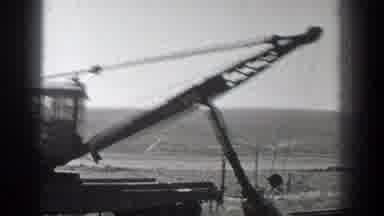 California (1936): Black Vintage Excavator Scoops Up Dirt On A Sunny Day