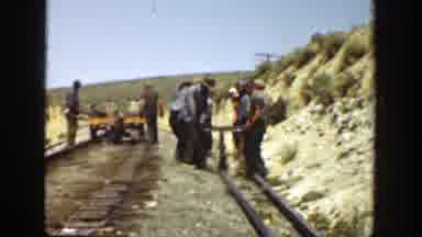 California (1936): Railway Workers Carrying A Piece Of Equipment Over Train Tracks
