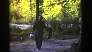 California (1936): Man Wearing Brown Shirt Carries Small Blue And White Case On A