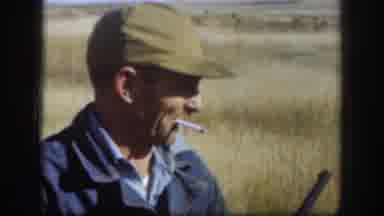 Kansas (1958): Two Hunters Carry Guns In A Winter Field While Wearing Caps And