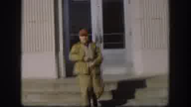 Kansas (1958): Man With A Red Cap Leaves Building Removes Item From Pocket