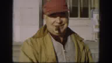 Kansas (1958): A Man In Yellow Jacket And Red Cap Smoking A Tobacco Walking Down