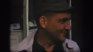 Kansas (1958): A Man Wearing A Cap Talks And Clowns Around While Standing In Front