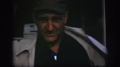 Kansas (1958): Two Men Wearing Caps And Coats Stand On A Street Sidewalk With