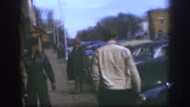 Kansas (1958): Man Wearing White Sweater Leaves Out Of White Building Through