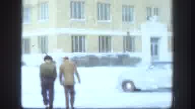 Kansas (1958): Two Men Walking Towards Yellow Building On A Windy Winter Day