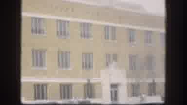 Kansas (1958): An Old Building With Yellowish Paint And Barred Windows