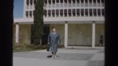 Israel (1960): A Grey Dressed Woman With A Black Bag Walking Away From A Tall