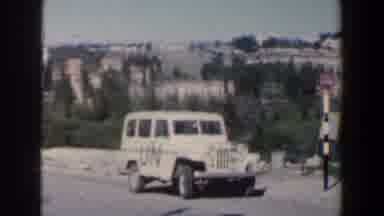 Israel (1960): View Of Parked White Car And Tan Building On A Bright Sunny Day
