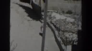 Israel (1960): Arab Woman With Veil Walking Fast Along A Stone Wall On A Sunny Day