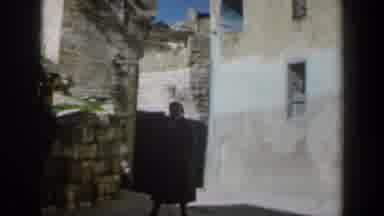 Israel (1960): An Older Woman Standing In Front Of A Stone Building For A Picture