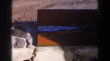 Israel (1960): View Of Orange Tackle box Sitting On Grey Rocks On A Sunny Day