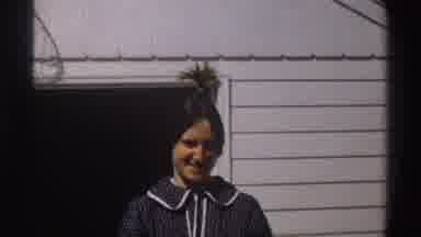 Michigan (1969): A Woman With Her Hair Spiked On Top Of Her Head Stands Outside In