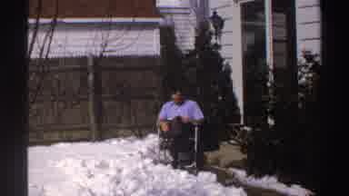 Michigan (1969): Man Reading In A Chair On A Patio With Snow On The Ground And