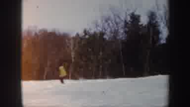 Vermont (1962): People Skiing Down A Snowy Hill With Bare Trees In The Background