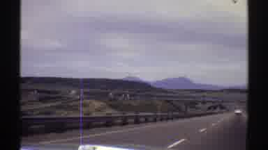 Colorado (1969): A Vehicle Driving On The Highway With A Car Ahead Of It