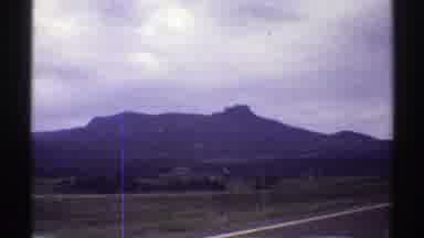 Colorado (1969): Driving Down The Road Surrounded By Trees And Wooded Mountains