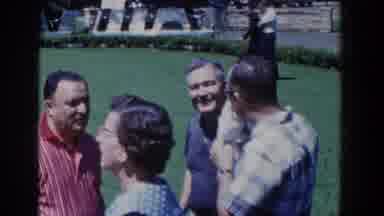 French Lick Indiana (1958): Man Wearing Blue Shirt Waves At Camera While Sitting
