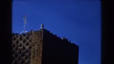 CASABLANCA-1959: The Corner Of A Very Tall Brick Building With Lattice Pattern And Weather Vane