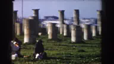 Casablanca (1959): Two Women In Veils Sit On The Grass Next To The Gray Cement