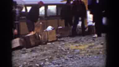 Chelan Washington (1939): People Carrying Various Packages Near A Train Carriage