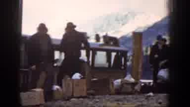 Chelan Washington (1939): Men Loading Brown Boxes Onto Brown Boat On A Clear Day