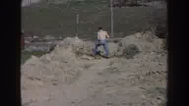Nebraska (1959): Shirtless Man In The Yard And Woman Stretching Clothes On Rope